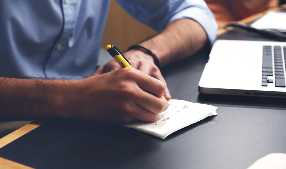 Man writing ideas on a notepad