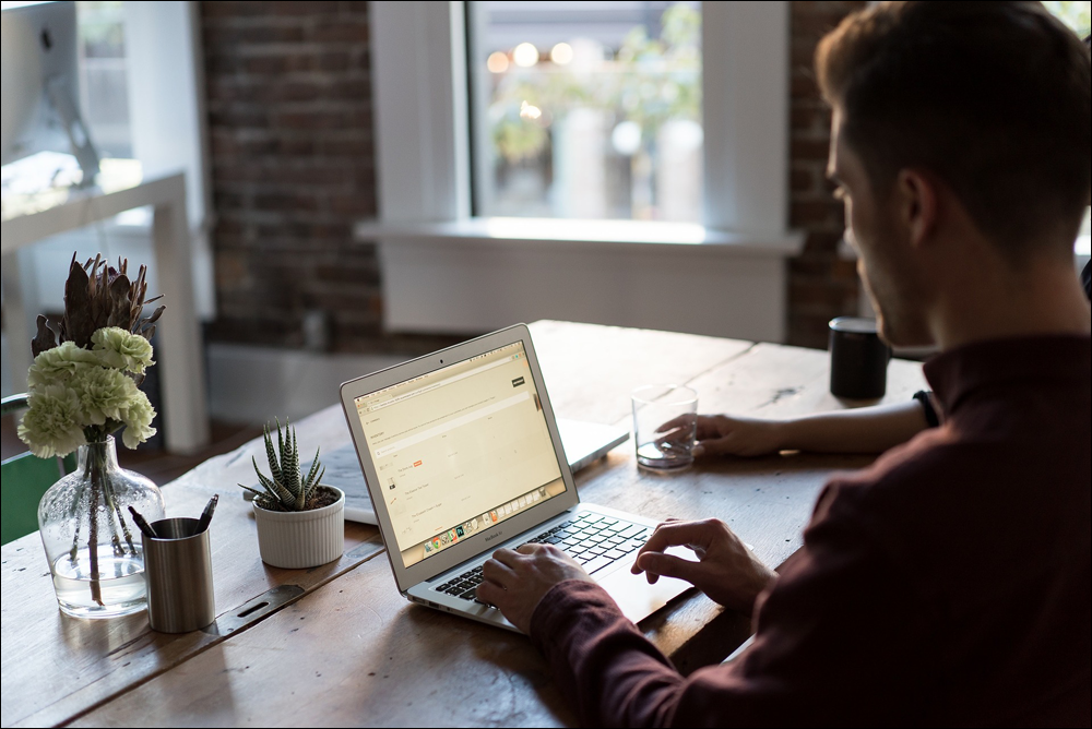 Man in office working on laptop.